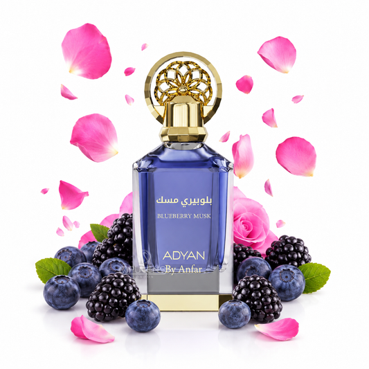 A blue glass perfume bottle with a gold cap and Arabic text reading 'بلوبيري مسك' and 'BLUEBERRY MUSK', surrounded by blueberries, blackberries, pink rose petals, and a pink rose on a white background. The brand name 'ADYAN By Anfar' is visible on the bottle.