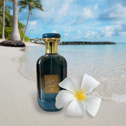 Ard Al Zaafaran Mousuf Azure Unisex EDP 100ml bottle on tropical beach with white flower