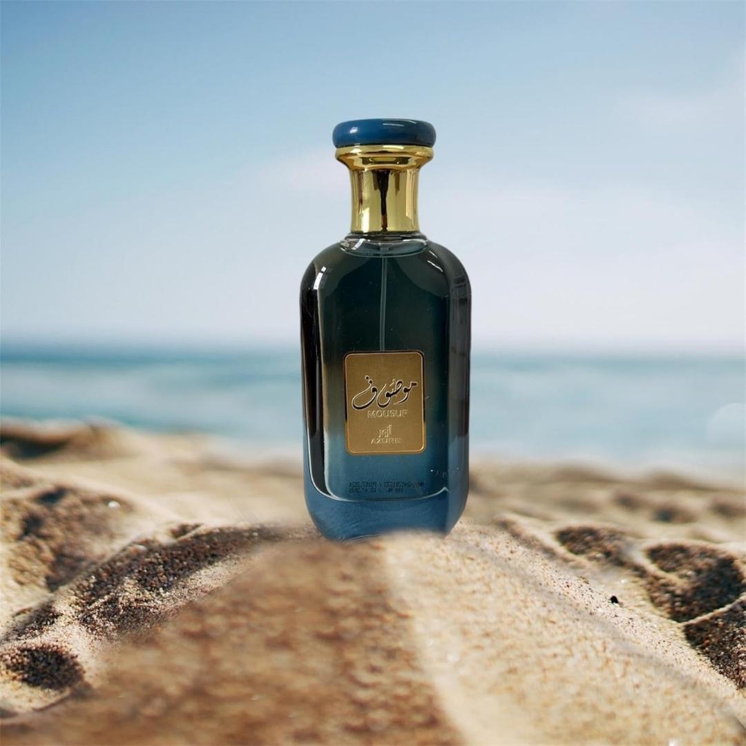 Ard Al Zaafaran Mousuf Azure Unisex EDP 100ml bottle standing on beach with sea in background