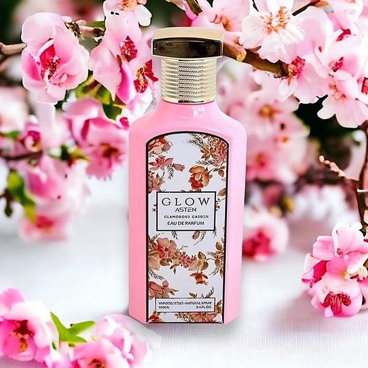 Asten Glow Glamorous Garden 100ml EDP bottle with pink blossoms background