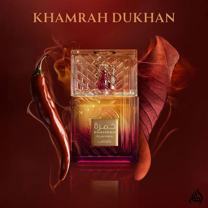 Khamrah Dukhan perfume bottle with a red leaf and chili pepper on a dark background