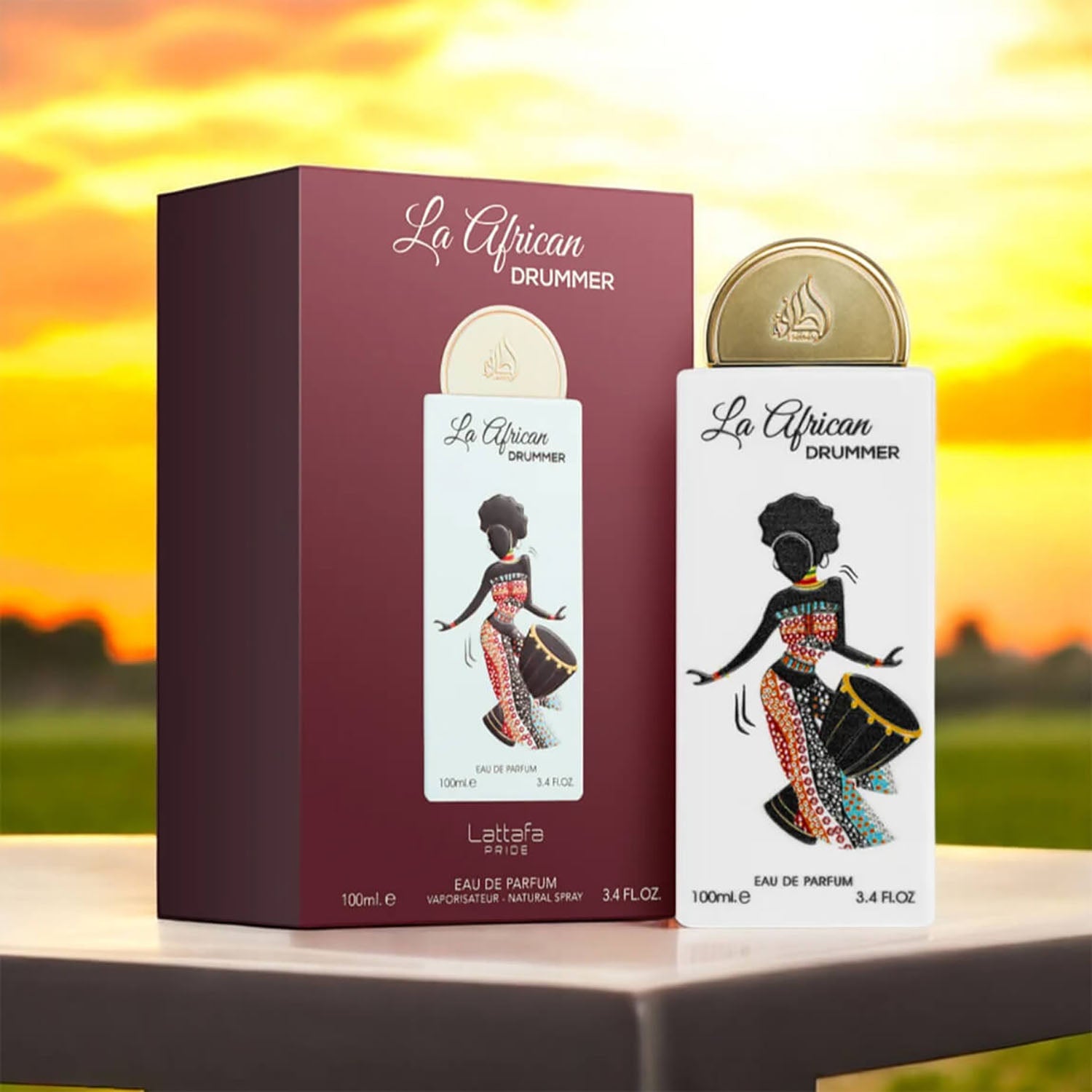 La African Drummer perfume bottle and packaging on a table with a sunset background