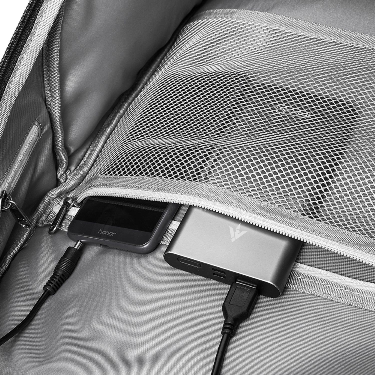 Portable charger plugged into a backpack with a smartphone on top best travel laptop backpack multi-functional