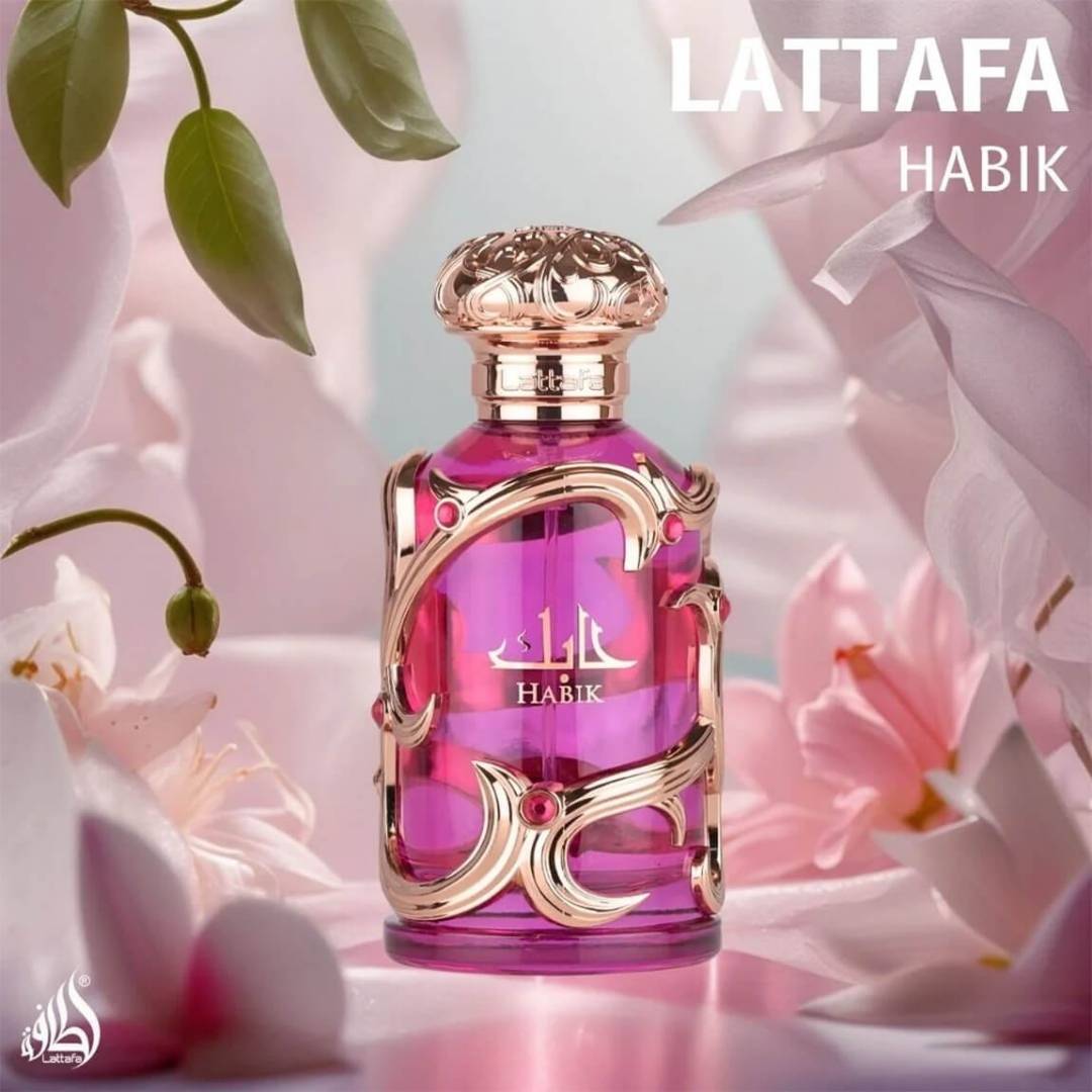 Lattafa Habik women's perfume bottle in pink with ornate gold design displayed among soft pink flowers, representing a romantic floral luxury fragrance.