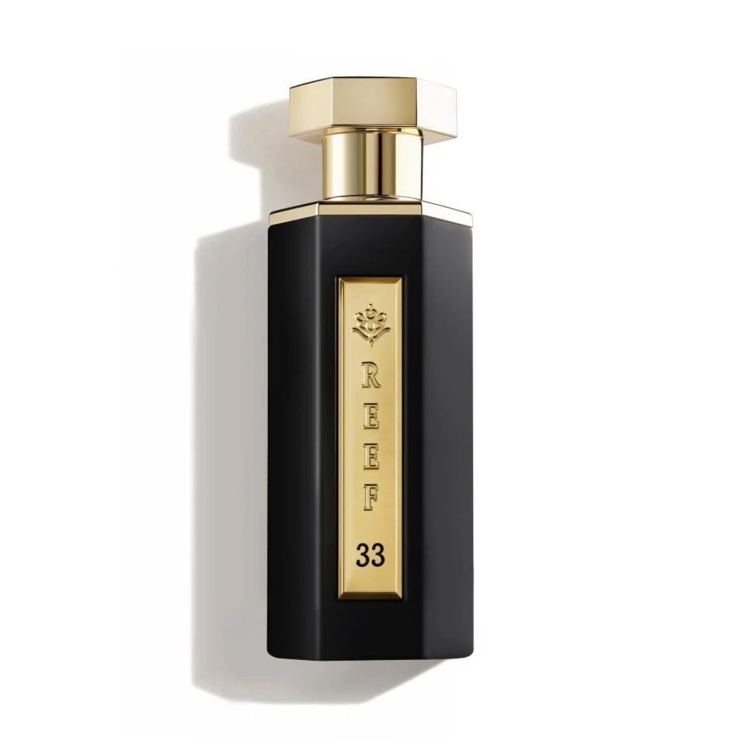 Reef 33 luxury perfume bottle in matte black with gold accents isolated on a white background, showcasing an elegant premium fragrance design.