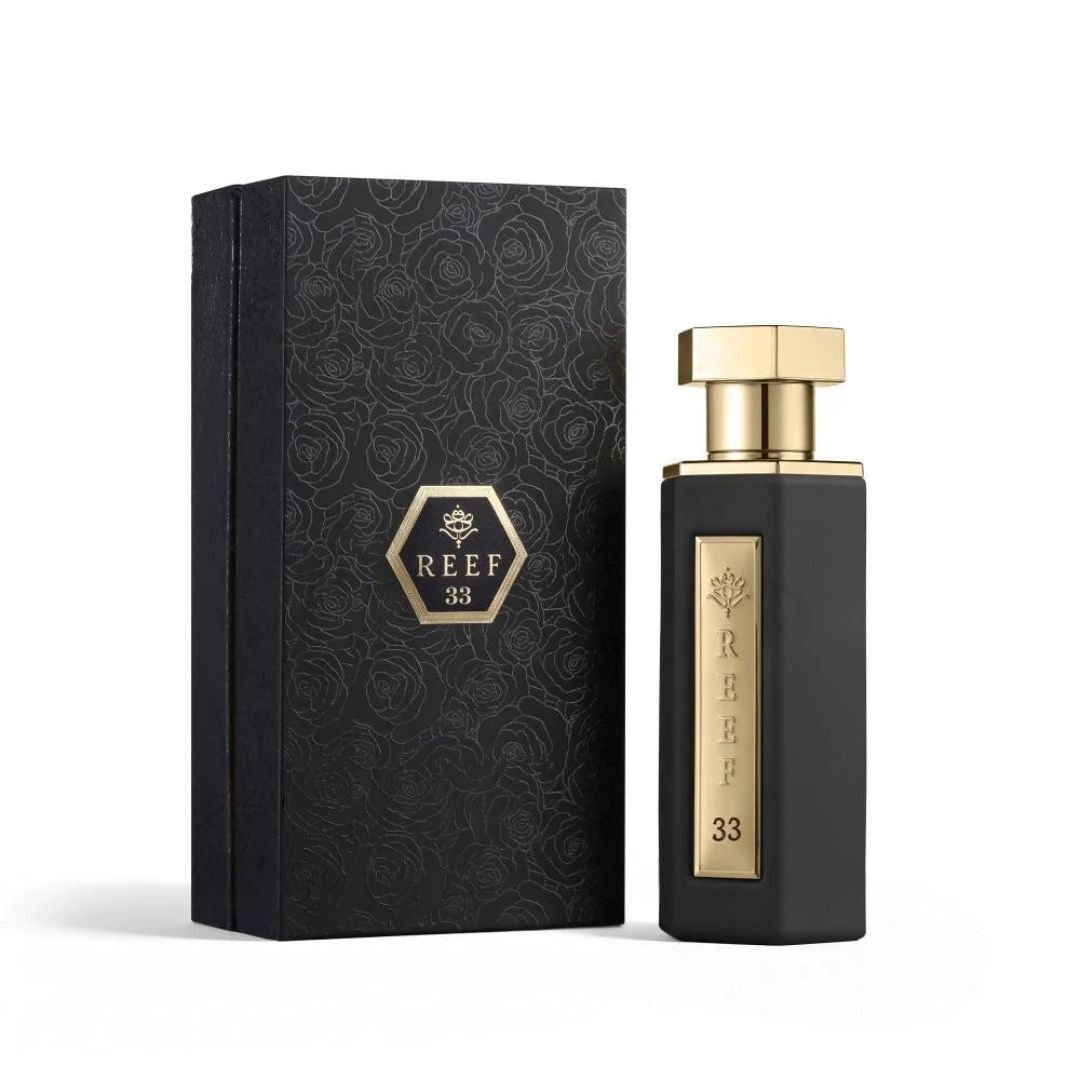 Reef 33 luxury perfume with black bottle and gold accents displayed beside its elegant patterned gift box packaging.