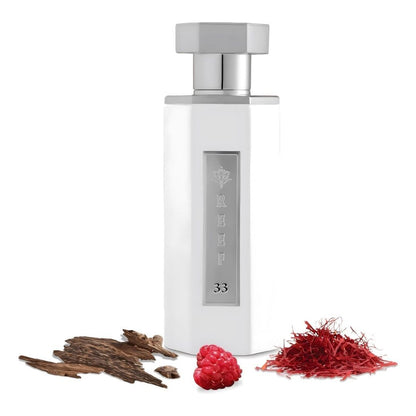 Reef 33 luxury perfume bottle in elegant white design displayed with saffron threads, raspberry, and agarwood oud representing rich oriental fragrance notes.