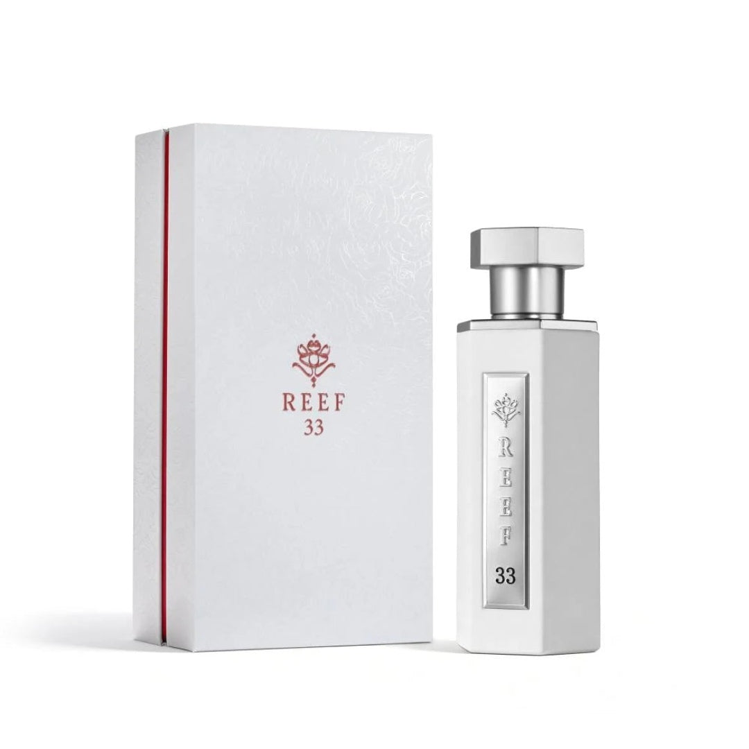 Reef 33 luxury perfume in elegant white bottle with silver cap displayed beside its premium white packaging box.