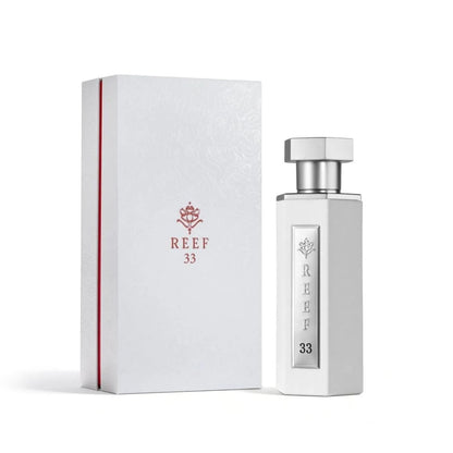 Reef 33 luxury perfume in elegant white bottle with silver cap displayed beside its premium white packaging box.