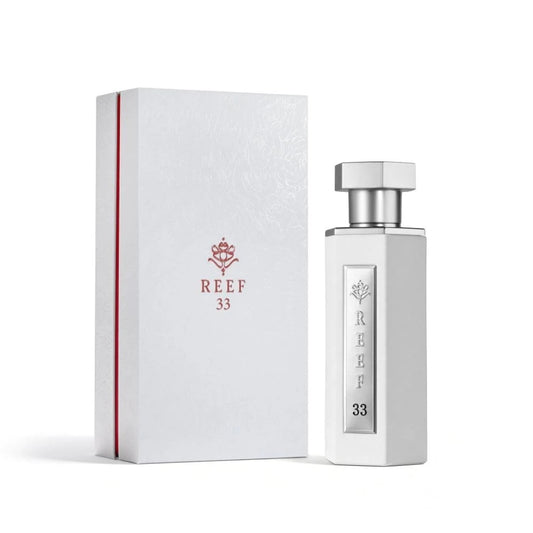 Reef 33 luxury perfume in elegant white bottle with silver cap displayed beside its premium white packaging box.