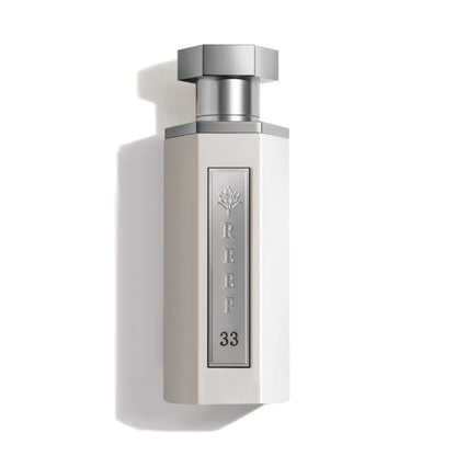 Reef 33 luxury perfume bottle in elegant white design with silver cap and metallic label, premium Arabian fragrance presentation.