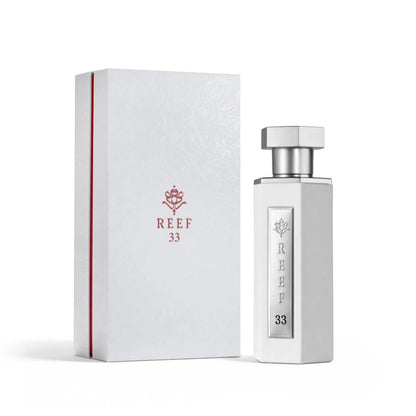 Reef 33 white unisex eau de parfum 100ml displayed with its elegant white embossed box, featuring a sleek white bottle with silver detailing in a refined luxury fragrance presentation.