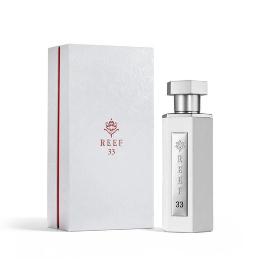 Reef 33 white unisex eau de parfum 100ml displayed with its elegant white embossed box, featuring a sleek white bottle with silver detailing in a refined luxury fragrance presentation.