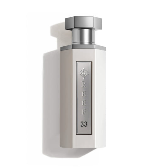 Reef 33 white unisex eau de parfum 100ml in a minimalist white bottle with polished silver accents, photographed on a clean white background with premium editorial lighting.