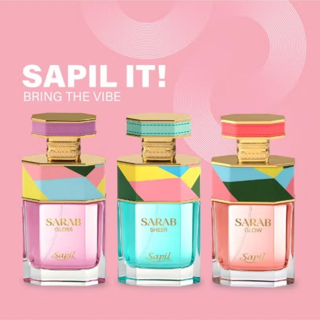 Sapil Sarab perfume collection featuring Sarab Gloss, Sarab Sheer, and Sarab Glow Eau De Parfum bottles with colorful geometric caps on pink background.